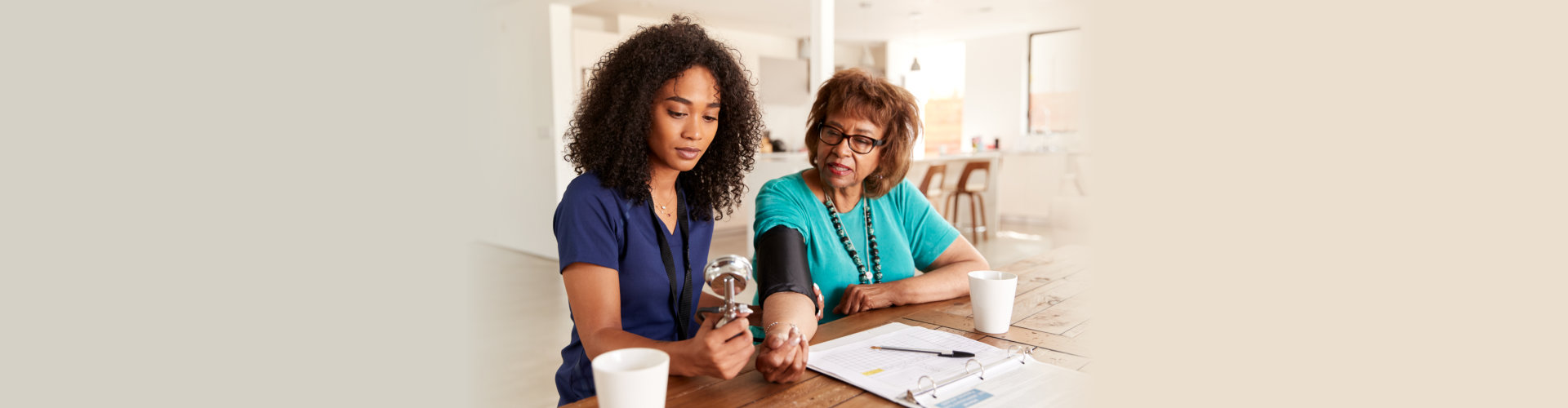 Female healthcare worker checking the blood pressure of a senior woman during a home visit